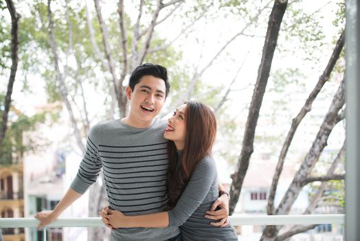 Couple in love sharing genuine emotions and happiness, hugging on the balcony