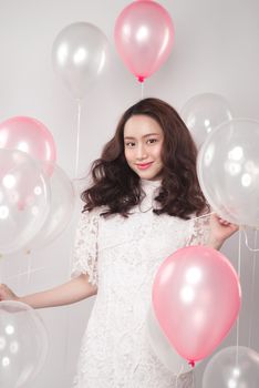 Asian pretty fashionable woman in white dress with pastel balloons