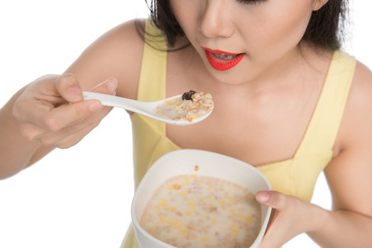 Asian woman eating bowl of cereal or muesli for breakfast