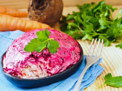 Close up view of homemade herring under a fur coat and ingredients. National festive Russian dish with beetroot. Served with fresh parsley