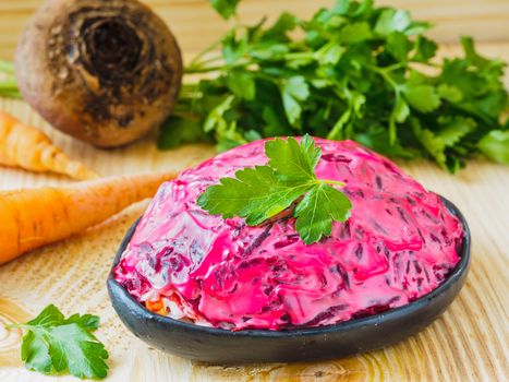 Close up view of homemade herring under a fur coat and ingredients. National festive Russian dish with beetroot. Served with fresh parsley
