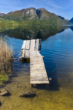 Countryside landscape, wooden bridge on a lake in the mountains 