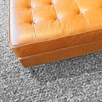 Close-up of a leather seat on gray wool carpet. Modern design.