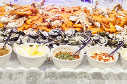 Seafood buffet on ice in a restaurant, with fresh shrimp squid clams crabs and lobster.
