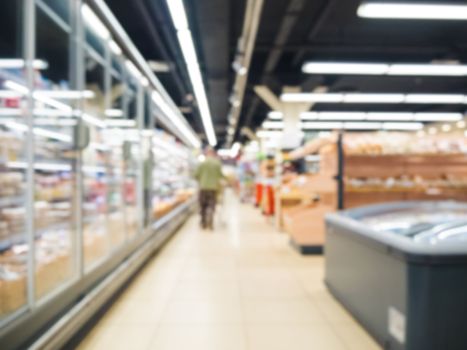 Abstract blurred supermarket aisle with colorful shelves as background