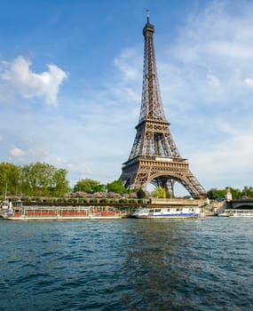 Eiffel Tower with river Seine on the foreground against of the sky in springtime in Paris, France.
