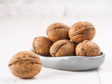 View on inshell walnut on white wooden background with copy space.