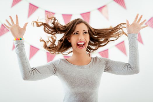 Beautiful young smiling woman having fun with flying long hair.