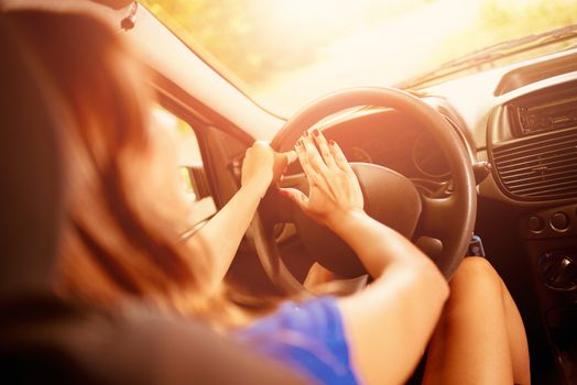 Close-up of a young woman's hand pressing in a car horn. Rear view.