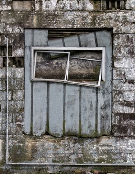 A dilapidated window on a brick building.