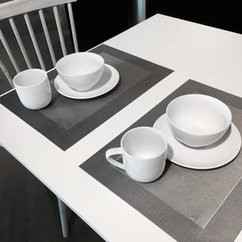 Simple table setting in white and gray tones.