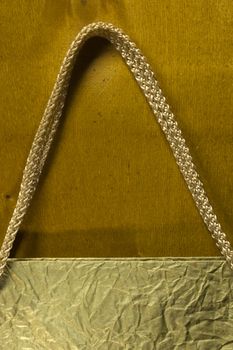 Rope handles from a paper bag on a wooden background