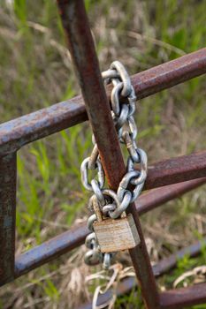 A chain and lock keeping a fence closed.