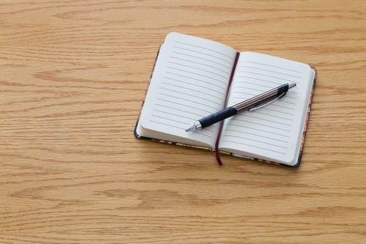 A pen on top of a blank notebook.