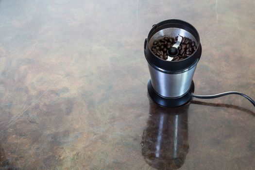 Electric coffee grinder with beans inside.