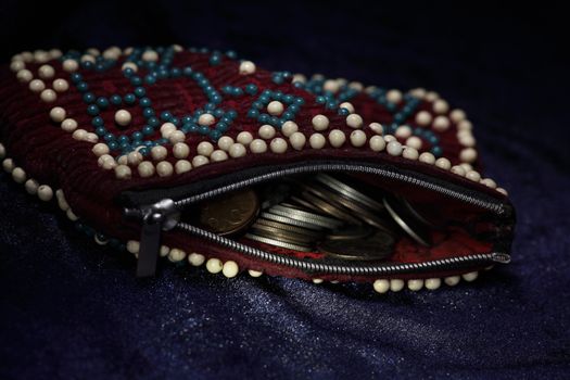 purse decorated with beads is full of gold and silver coins