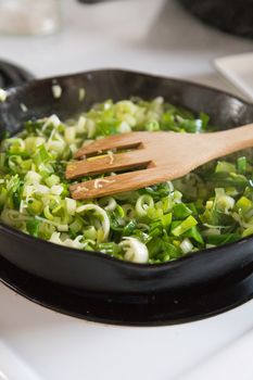 Cooking leeks and onions in a cast iron pan.