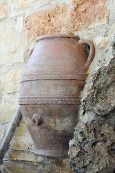 Greek amphora encrusted in a stone wall on a terrace