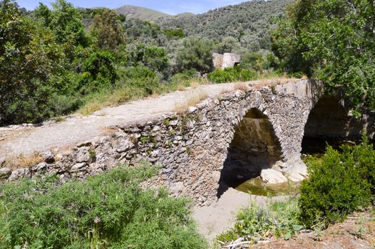 Old stone bridge with arches in the mountains of central Crete