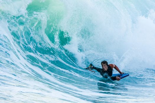 Bodyboarder in action on the ocean waves on a sunny day.