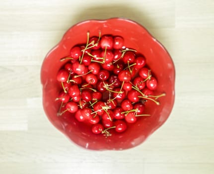 aerila shot of cherries on a red ceramic plate