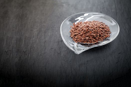 Flax seed in glass bowl a stone plate