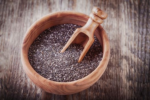 A bowl of Chia Seeds on a wooden table