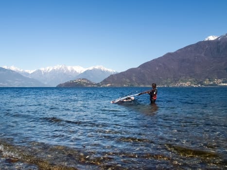 Pianello del Lario, Como - Italy - March 28, 2015: Windsurfer start from the beach and goes in search of strong winds towards the center of the lake.