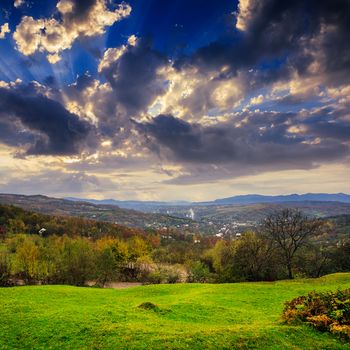 autumn landscape. village on the hillside. forest on the mountain light fall on clearing on mountains