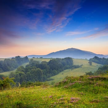 cold morning fog with red hot sunrise in the mountains