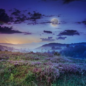 cold morning fog with red hot sunrise in the mountains in moon light