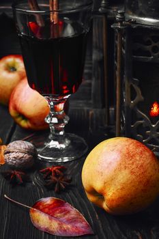 Warming autumn cocktail sangria with apple in glass wine glass.Dark key
