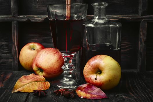 Warming autumn cocktail sangria with apple in glass wine glass.Dark key
