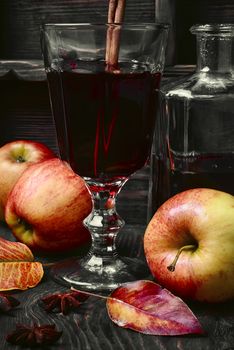 Warming autumn cocktail sangria with apple in glass wine glass.Dark key