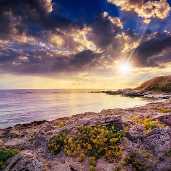 sea ​​wave attacks the boulders and is broken about them at sunset in evening light