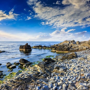 sea wave attacks the boulders and is broken about them