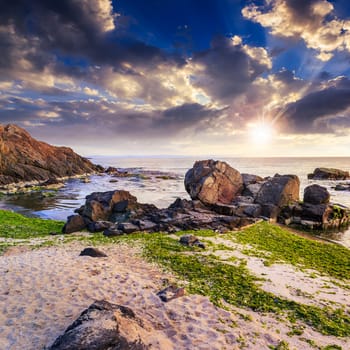 sea wave attacks the sandy beach and break on them at sunset