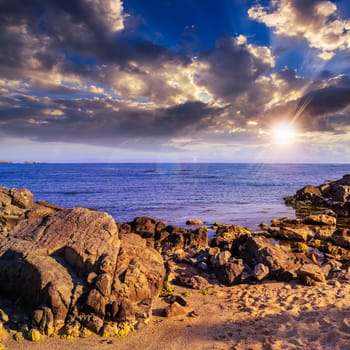 sea wave attacks the sandy beach and break on them at sunset