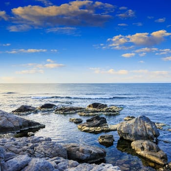 sea wave attacks the boulders and is broken about them