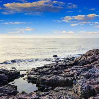 sea wave attacks the boulders and is broken about them