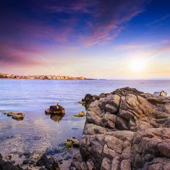 sea coast with boulders near liitle town at sunset