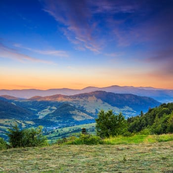 summer landscape. village on the hillside. forest on the mountain motning light fall on clearing on mountains