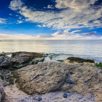 sea wave attacks the boulders and is broken about them