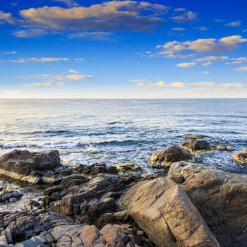 sea wave attacks the boulders and is broken about them