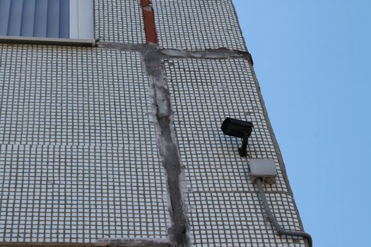 CCTV camera hanging over the entrance of a house.