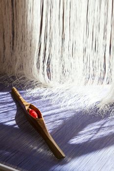 Yarn background, old weaving Loom and thread of yarn. A traditional hand-weaving loom being used to make cloth at home.