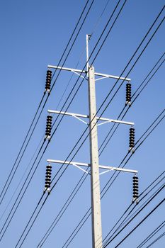 Power pole on stand. Electrical wires on a pole on blue sky background. Electric supply of big city. Land communications.