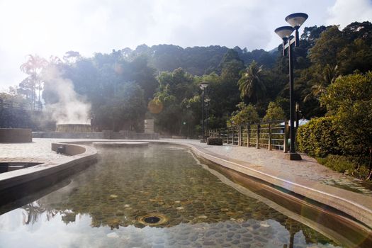 volcanic natural hot spring mineral water pool with steam spa and sun reflect light travel landmark background lampang thailand landscape colorful dark tone