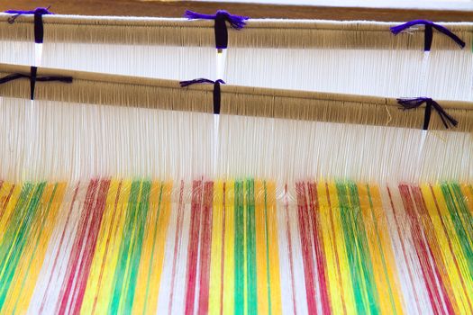 Yarn background, old weaving Loom and thread of yarn. A traditional hand-weaving loom being used to make cloth at home.