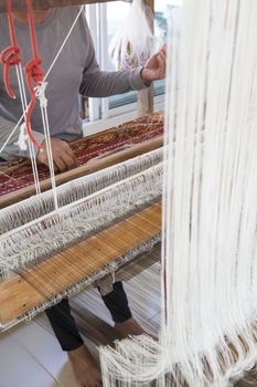 Old asia women demonstrate to procedure of making Thai Silk weaving in small weaving mill